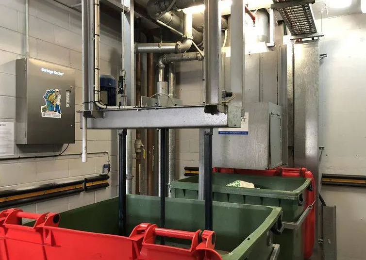 Garbage chute discharge and sorter above collection bins in a garbage room