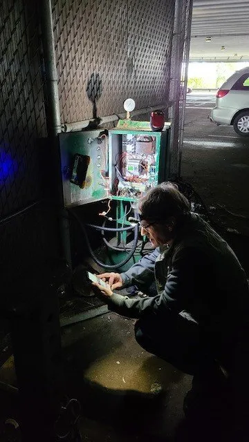 WasteMind technician diagnosing a compactor's electrical control panel